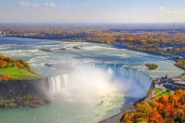Toàn cảnh thác Niagara hình vòng cung với hơi nước và hàng cây mùa thu bên bờ