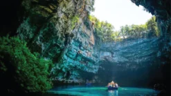 Du khách đi thuyền trên dòng nước xanh trong hang động - Royal Tourist